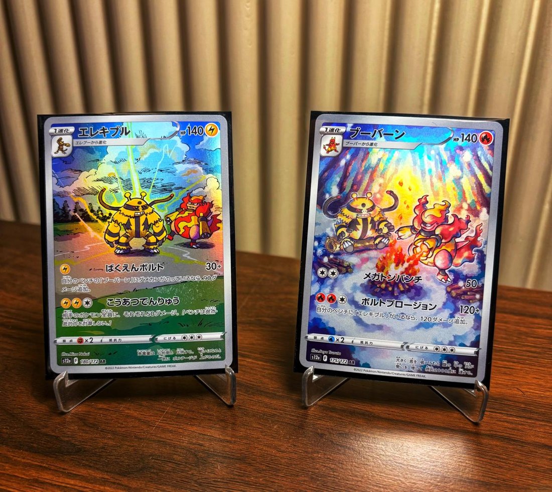 Two graded Pokémon cards displayed on stands